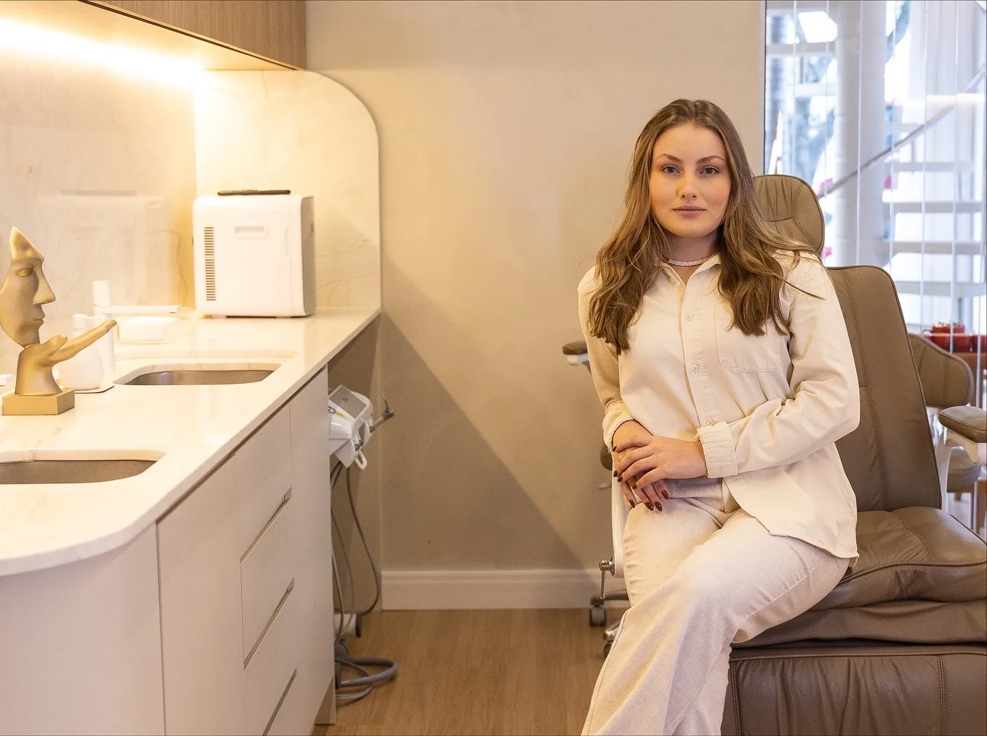 Dra. Jacqueline Ferreira Basan sentada na sala de atendimento da FB Clinic